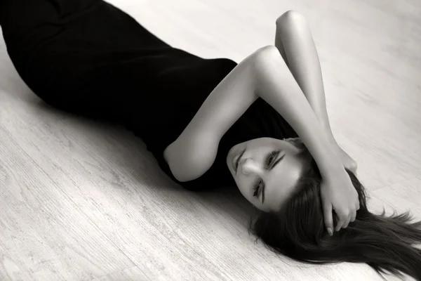 Attractive girl lying on the floor of the wood