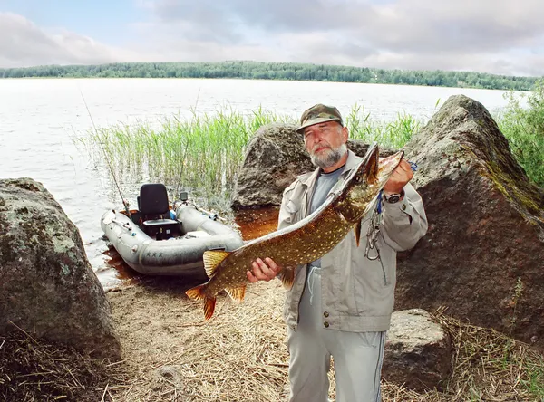 Angler catch big pike fish, fishing on lake with boat
