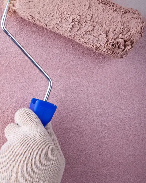House painter using a paint roller, painting a wall in motion