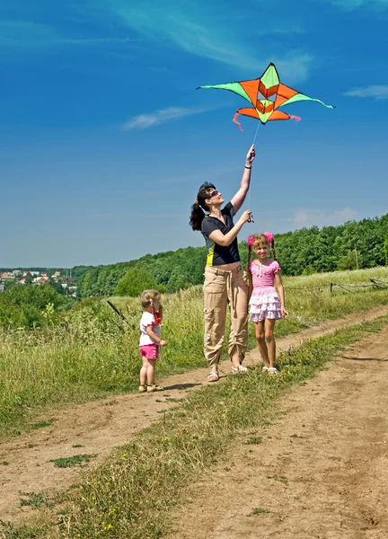 Happy family and children fly kite. Summer.