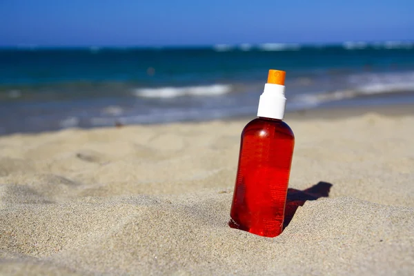 Spray tube with sun protection on beach of ocean