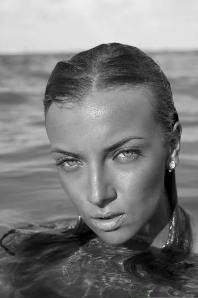 Portrait of beautiful girl in water closeup