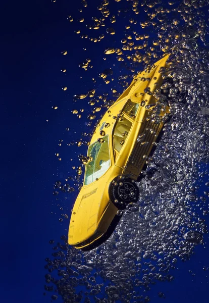Yellow sportcar accident, going down underwater with air bubbles