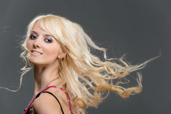 Portrait of beautiful young blonde girl with flying long hair