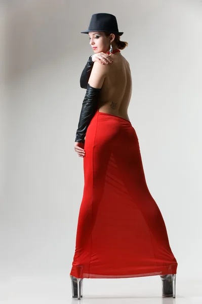 Sexy woman in red dress and black hat.