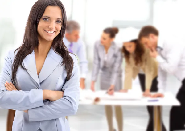 Portrait of a charismatic woman at a meeting while her team working in the