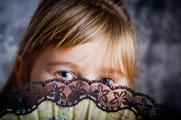 Girl covering her face with a lacy fan — Stock Photo #4412208