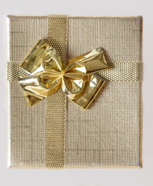 Holidays background of golden box with ribbon — Stock Photo #5054217