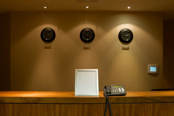 Hotel reception desk with phone and signboard