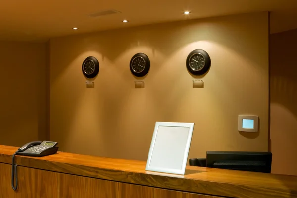 Reception desk with phone and row of clock