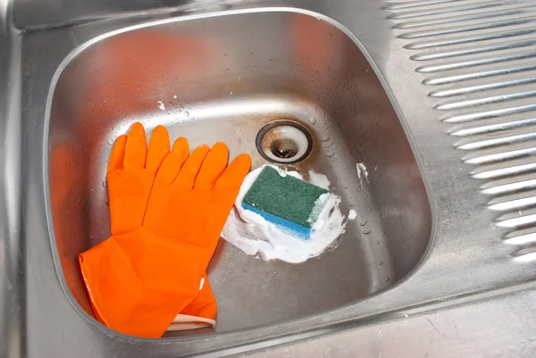 Cleaning the kitchen sink with a glove