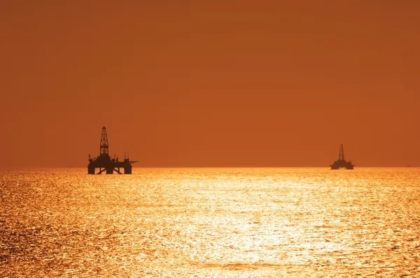 Two offshore oil rigs during sunset in Caspian se