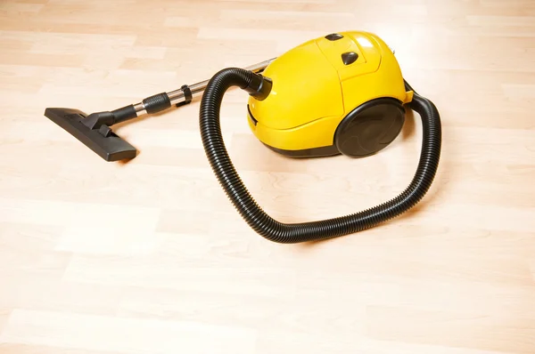 Vacuum cleaner on the polished wooden floor