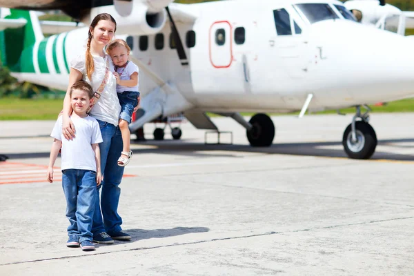 Mother and kids in front of airplane