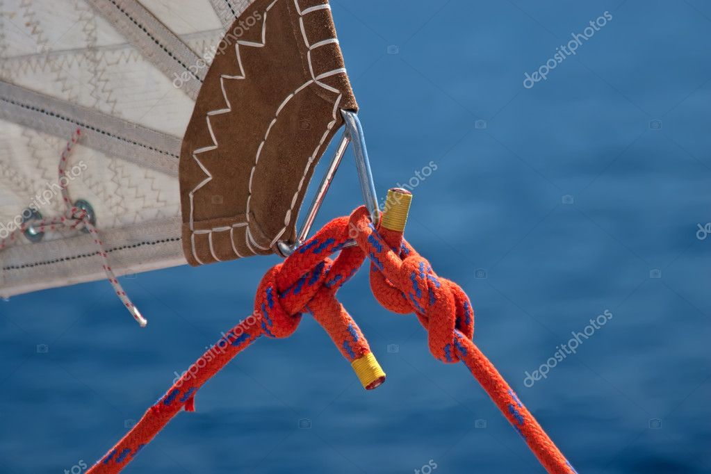 Red rope, knot and piece of sail - Stock Image