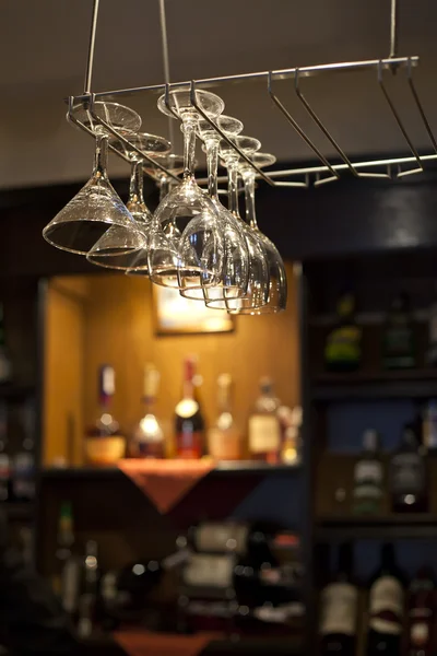 Wine glasses hanging near bar counter