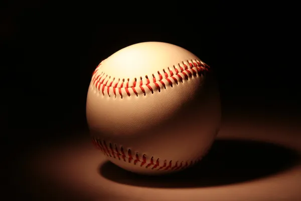 White baseball against dark background