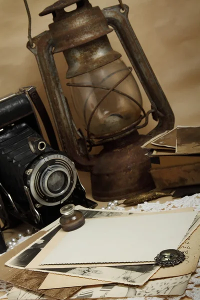 Retro camera, kerosene lamp and old photos