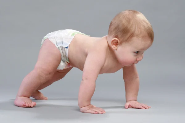 Little boy in pampers crawling