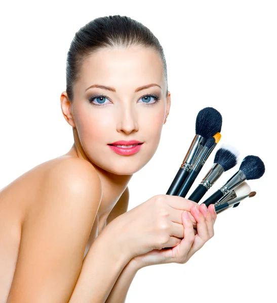 Portrait of the beautiful woman with make-up brushes