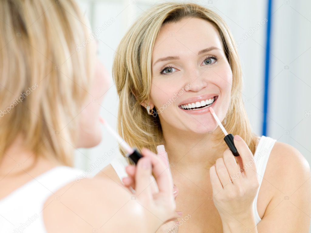 Beautiful young girl puts a lip gloss — Stock Photo © valuavitaly 4897317