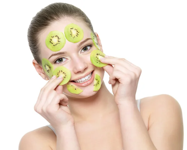 Happy adult woman with kiwi facial mask