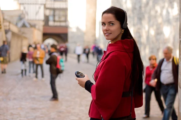 Young woman with headphones, listening to audio guide