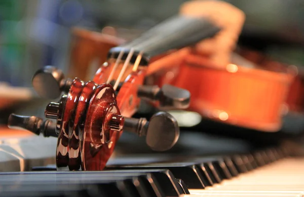 The violin lies on keys of the piano