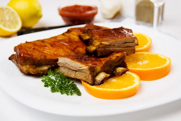 Barbecued ribs with orange slices