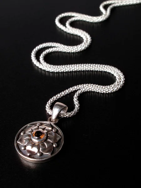 Sterling silver chain with pendant on the black background