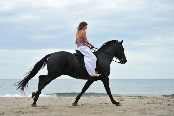 Woman and horse on the beach