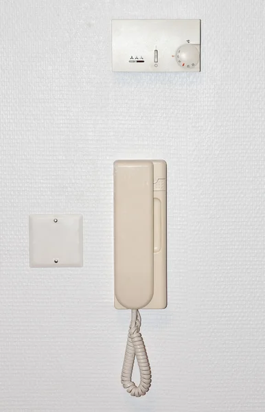 Beige intercom on a white wall