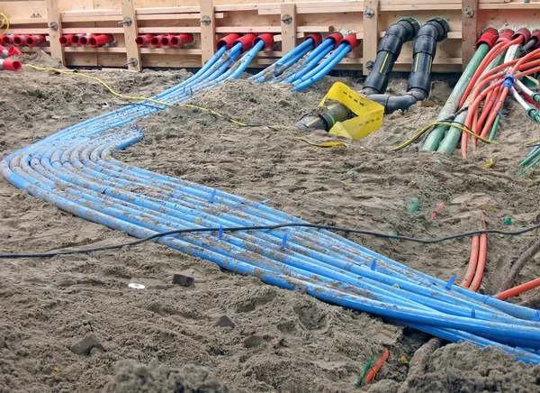 Color cables heap on sand, construction site diversity.