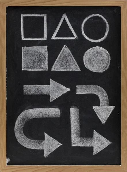Geometrical shapes and arrow - white chalk on blackboard
