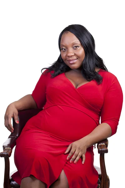 Young Black Pregnant woman sitting chair red dress by Jeff Cleveland Stock 