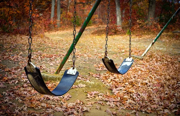 Old swingset at a park in the fall