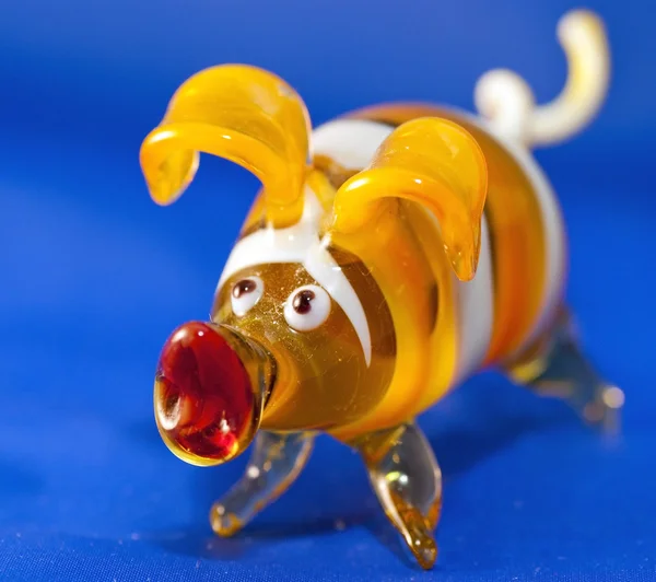 Yellow toy pig against the blue background