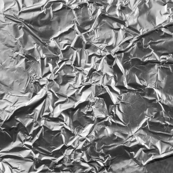 Natural crumpled silver aluminum foil closeup background textur