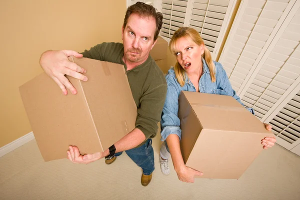 Exhausted Couple Holding Moving Boxes