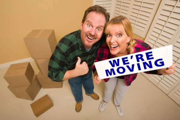 Goofy Couple Holding We\'re Moving Sign Surrounded by Boxes