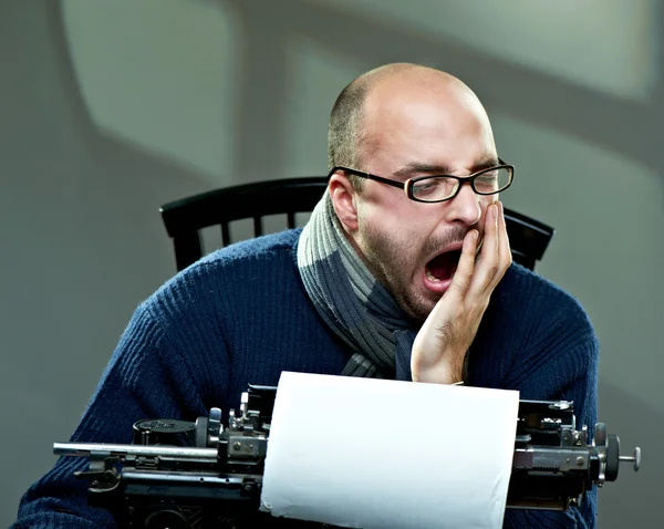 Serious bald man in scarf and glasses yawning