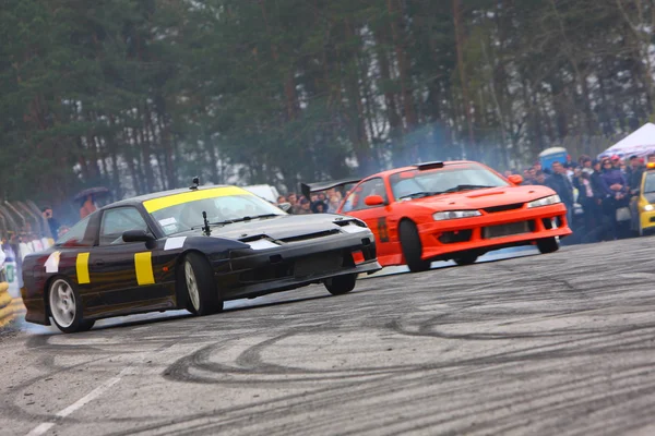 Black and red racing car drifting on road by Artur Shevel Stock Photo