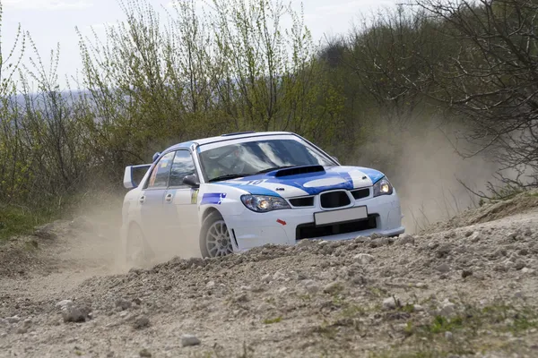 White racing rally car on gravel road