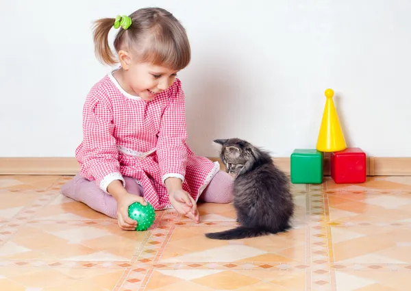 The girl plays with a kitten