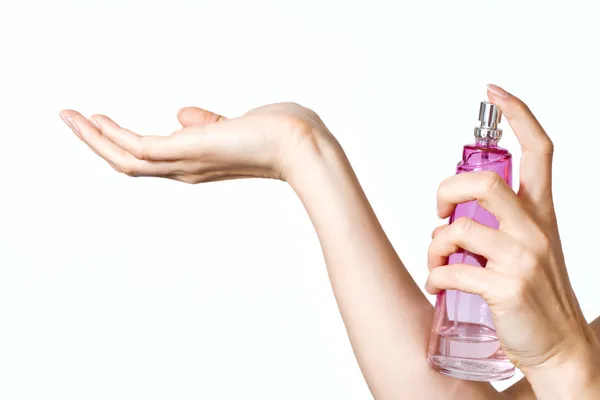 Woman hands with pink perfume bottle