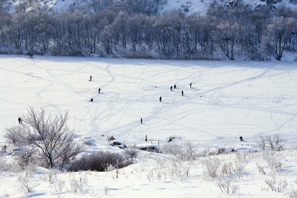Cold winter. Frozen river. Peoples on ice.