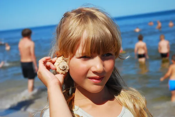 Young girl on beach with shell by Teresa Kasprzycka Stock Photo