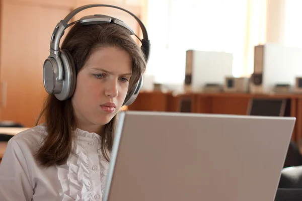 Girl is using computer with headphones