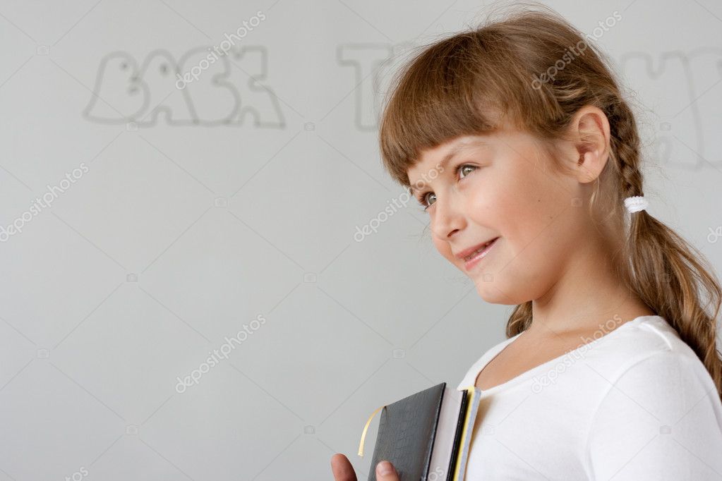 Cute preteen schoolgirl portrait near whiteboard