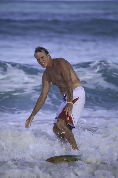 Sixty-four year old man surfing